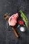 Organic cutlet on a rib or Pork meat over american classic butcher knife or cleaver with spices and rosemary and red pepper on