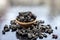 Organic dry fruit dried black grapes or black raisins or kali kishmish or black currant in a clay bowl on wooden surface.