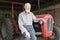 Organic Farmer Sitting By Vintage Tractor