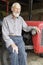 Organic Farmer Sitting By Vintage Tractor