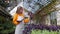 organic farming in greenhouse, young woman farmer examining plants, portrait, agribusiness