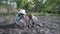 Organic farming, little male children in a hat and boots plant seedlings in spring season in garden