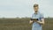 Organic farming. A young farmer works near heaps of compost or manure, uses a tablet