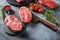 Organic feather steak  steak on chopping board, marbled beef over other alternative cuts  with herbs tomatoes peppercorns over