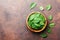 Organic food. Baby spinach leaves in wooden bowl on rustic stone table top view. Copy space for text.