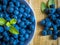 Organic fresh blueberries in bowl with mint leaves on a wooden table.