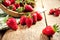 Organic fresh ripe strawberry on an old vintage wooden table. Berries are poured from a wooden bowl on a background.