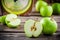 Organic green apples in colander on rustic wooden background