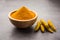 Organic Haldi or Turmeric powder spice pile in a bowl with whole, selective focus