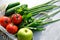 Organic health food concept. Mesh grocery bag with fresh raw vegetables and fruits on stone concrete table. Close-up view on