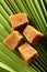 Organic jaggery cubes on palm tree leaf