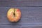 Organic juicy bio apple ugly, with defects edible lies on a wooden table. No ugly food