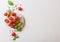 Organic Mini San Marzano Tomatoes on the Vine with basil and pepper on chopping board on white kitchen background. Space for text