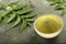 Organic neem leaves powder in ceramic bowl.