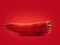 An organic pointed pepper on a red background