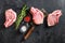 Organic Pork meat chop set over american classic butcher knife or cleaver with spices and rosemary and red pepper on black slate