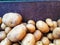 Organic potato stand out among many large background potatos in the market. Heap of potatos root