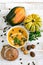 Organic pumpkin soup in a white bowl framed by chestnuts pumpkins parsley and chestnut bread