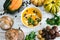 Organic pumpkin soup in a white bowl framed by chestnuts pumpkins parsley and chestnut bread and pumpkin seeds