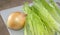 Organic Romaine lettuce leaves and a onion on chopping board