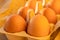 Organic rustic golden eggs shining glowing yellow orange in the light of the sun in a cardboard on kraft paper, carton