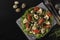 Organic salad with chicken, cherry tomatoes, quail eggs, black olives and microgreens against on a dark background, Healthy Eating