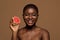 Organic Skincare Concept. Portrait Of Beautiful Smiling Black Lady Holding Grapefruit Half