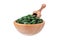 Organic spirulina and chlorella pills in a wooden bowl with a scoop isolated on white