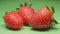 Organic strawberry close-up. Harvest ripe berries. 4K video. Green background.