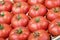 Organic tomatoes in a row in a paper box