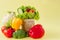 Organic vegetables broccoli cucumbers bell peppers apples in brown paper Kraft grocery bag on yellow background. Healthy diet