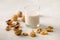 Organic walnut nuts and glass of walnut milk on stone background