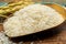 Organic white uncooked rice and dried basmati rice plant onwooden table