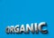 Organic word as 3D sign or logo concept placed on blue surface with copy space above it. Organic technologies concept. 3D