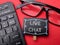 Organized desk station featuring a computer keyboard, glasses and live chat sign nearby