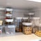 An organized pantry shelf with various types of cookies, cereal and snacks