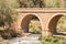 ORGIVA, SPAIN - 16 MAY 2022 The Seven Eyes Bridge over the Guadalfeo river near the tiny mountain village of Orgiva, Spain