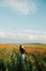 Oriental girl is standing in a field of poppies.young girl enjoys a summer sunset. Copy space for text