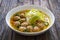 Oriental soup with meatballs, rice noodles and sprouts on wooden table