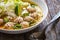 Oriental soup with meatballs, rice noodles and sprouts on wooden table