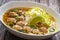 Oriental soup with meatballs, rice noodles and sprouts on wooden table