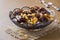 Oriental sweets, dried fruit dates and raisins, cinnamon and star anise in a plate on a wooden background.