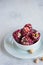 Oriental sweets, Turkish delight with rose petals and pistachios in a white bowl on a light concrete background