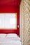 Oriental vintage bedroom in old house with red wall and carved wood partition
