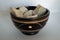 Oriental wood bowl with notches white stones inside on white background