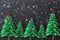 Origami Christmas trees form green folded paper on dark background