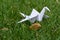 Origami crane in grass nature setting