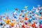 origami cranes in flight against a blue sky background