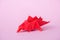 Origami dinosaur on pink with copy