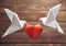 Origami dove couple around paper heart.